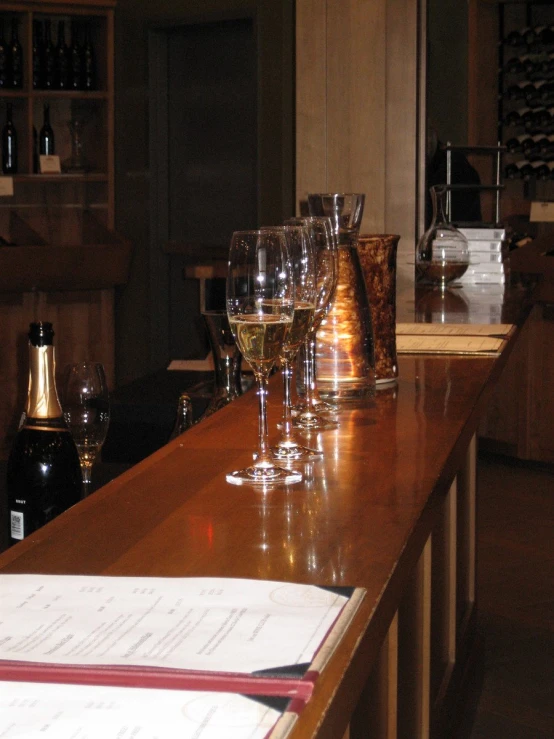 a long line of wine glasses sitting on a bar