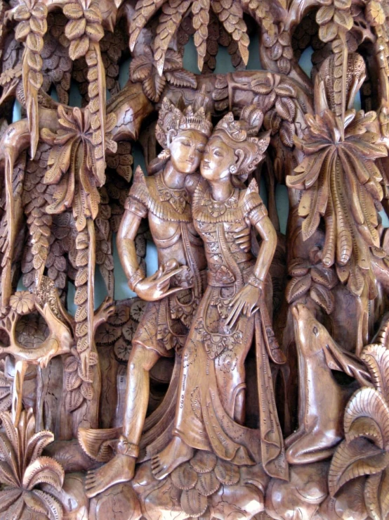 a carving of a woman standing next to a tree and other wood carvings