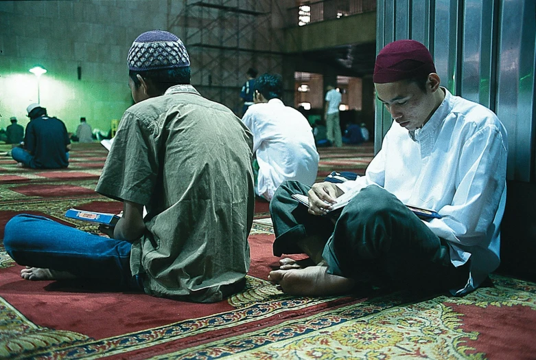 several men sitting on the floor of a building