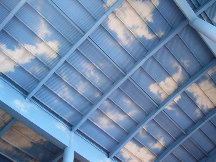 the sky and clouds appear to be reflected in the roof