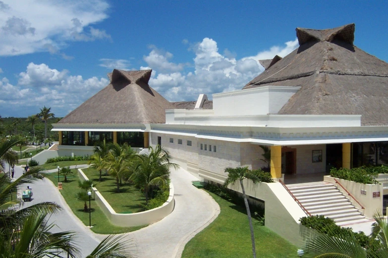 large open and modern building, with white stone architecture and grass lawn