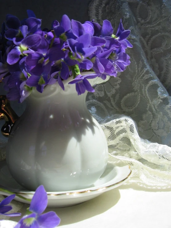 an empty vase on a table with flowers in it