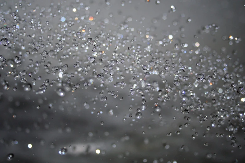 rain drops from the window on top of a cloudy sky