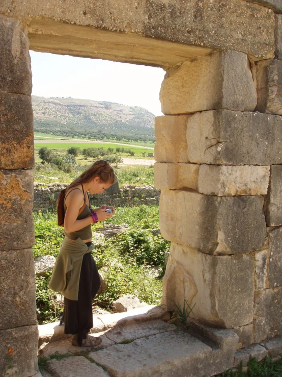 a man standing in front of an arch while looking at his phone