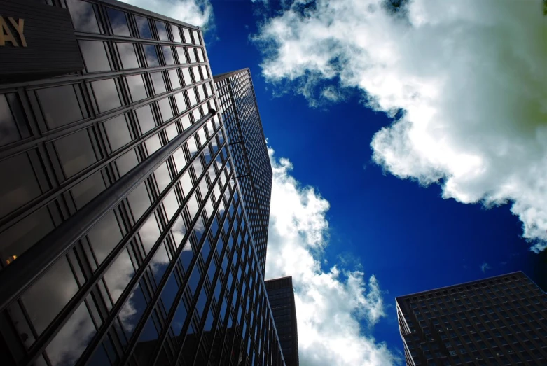 three large skyscrs with very cloudy blue sky in the background