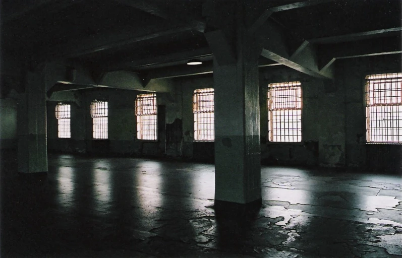 an empty building with two windows and some tables