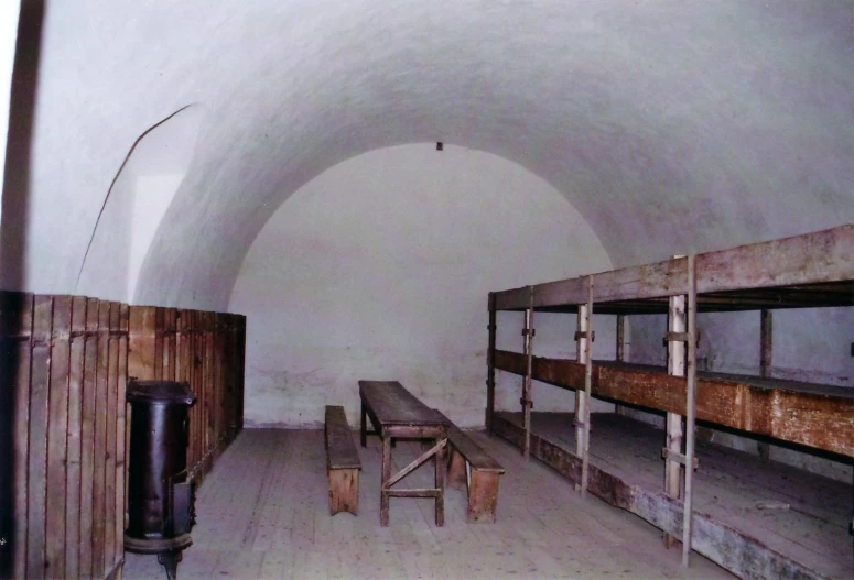 a room filled with lots of wooden bunk beds