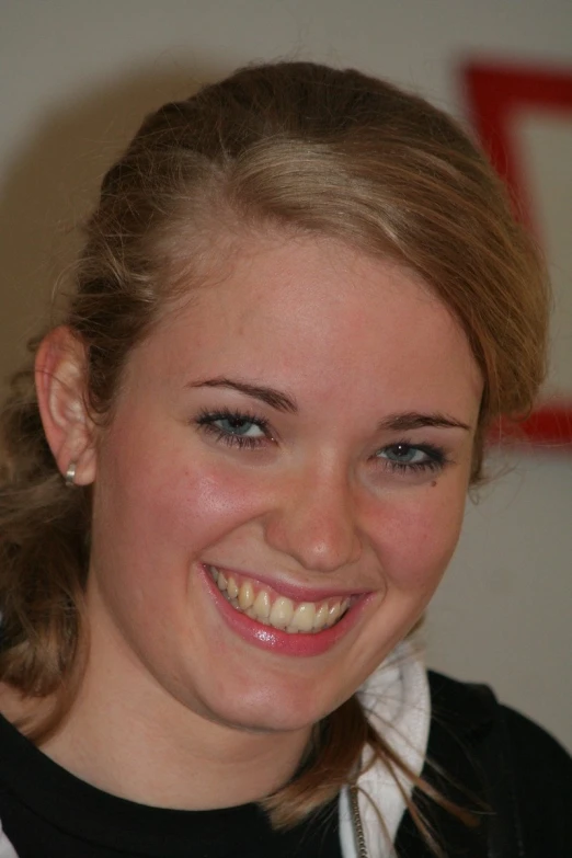 a smiling girl looking at the camera with blue eyes