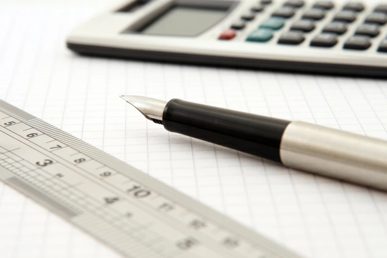 a pen and a ruler are laying on a table