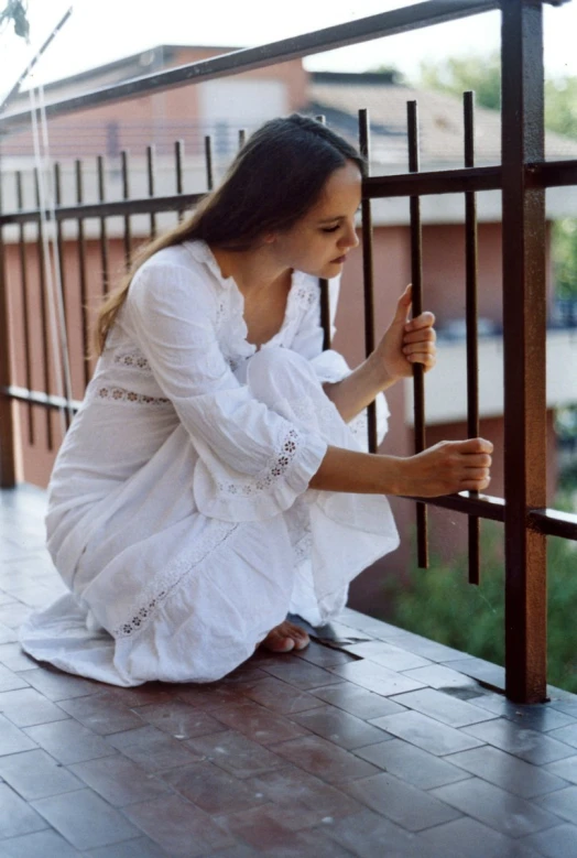 a woman kneeling on the ground holding a cup