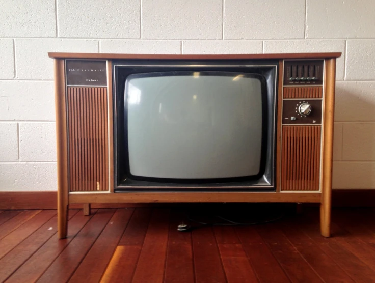 an old, wooden tv set sitting on a hard wood floor