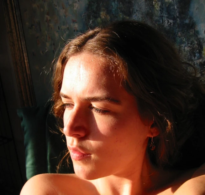 a woman sitting in the sun and looking straight ahead