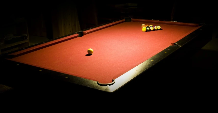 three pool balls are sitting on an orange cloth covered pool table
