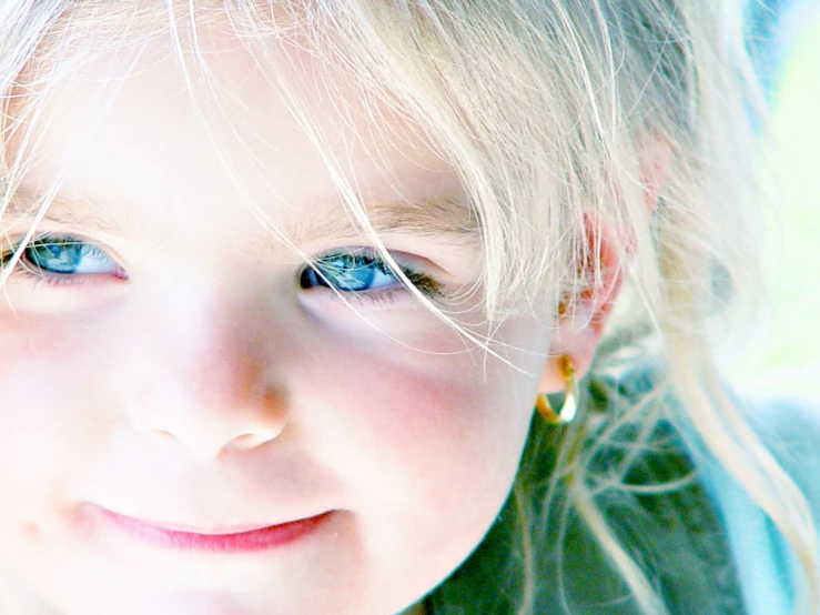 a little blonde girl with blue eyes with big lashes and blonde hair