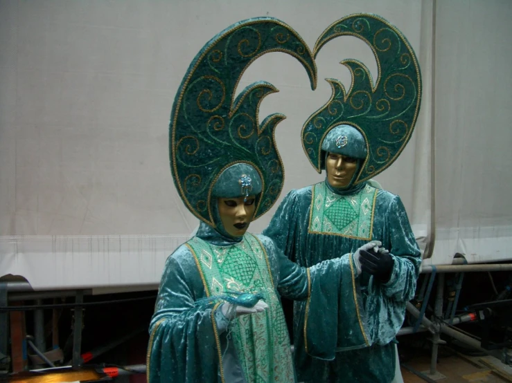 two statue's standing in front of a large truck