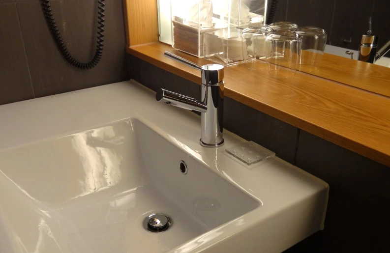 a small bathroom sink under a counter with soap and lotion