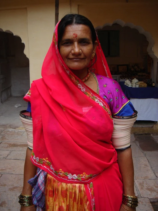 an indian woman in traditional clothing with a pot on her shoulder