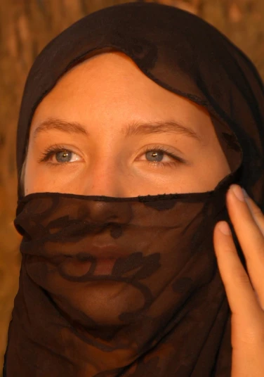 the woman is wearing a black veil covering her head