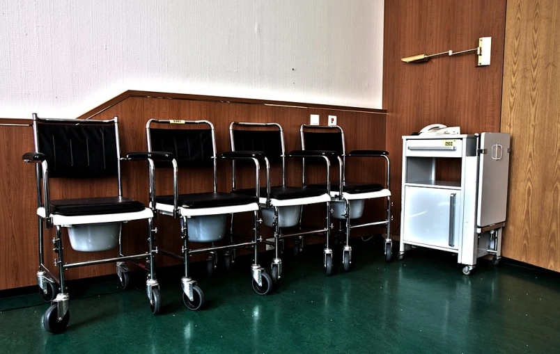 several chairs are lined up near a small cabinet