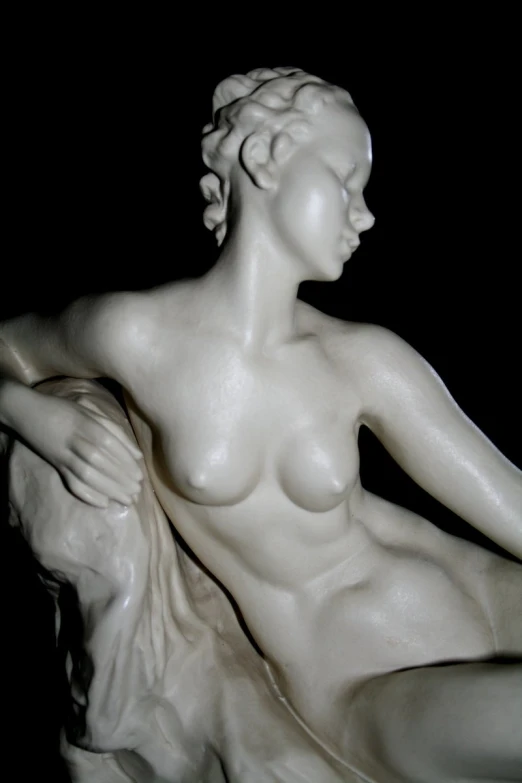 a statue of a female  sitting and holding her hand up