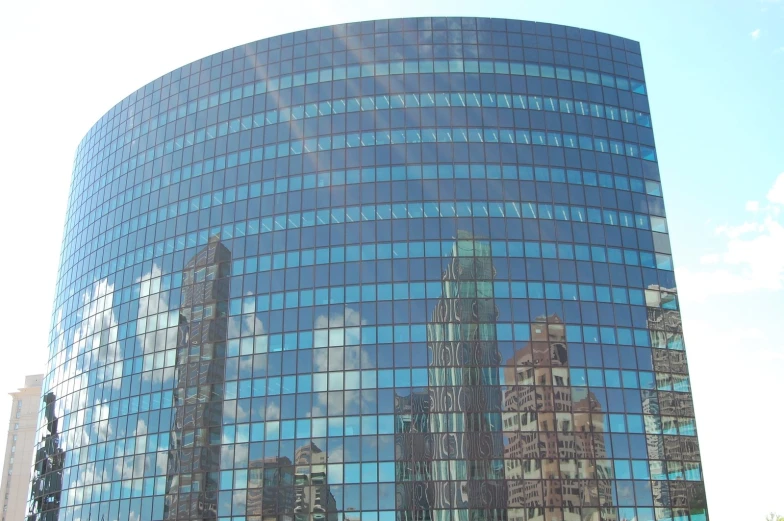 a building with glass windows reflects skyscrs in its reflection