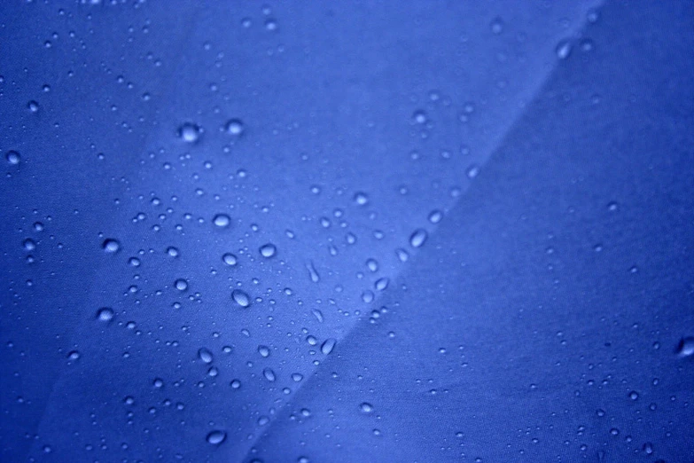 drops of water on a shiny surface with a blue color