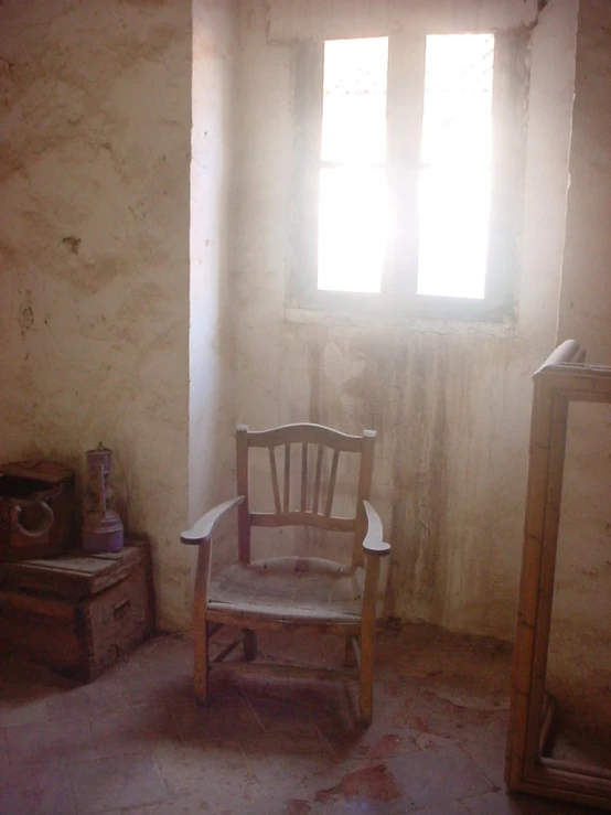 an old chair sitting in front of a window in a room