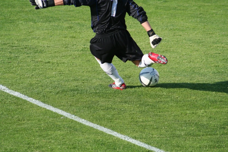 a soccer player wearing black playing with his ball
