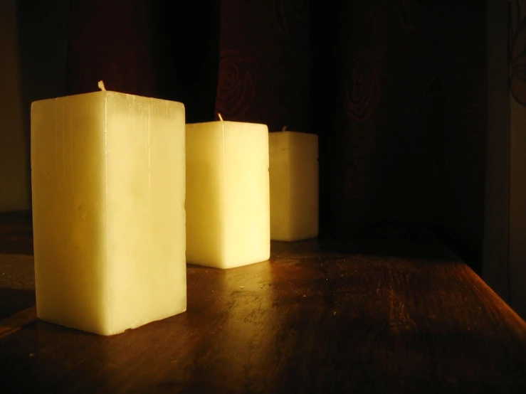 three candles sitting on top of a table next to each other