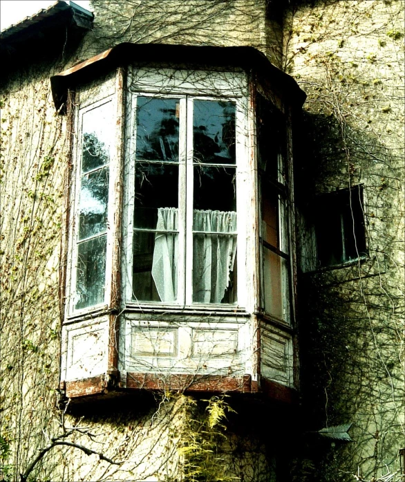 an old building with a small window sitting next to the side of it