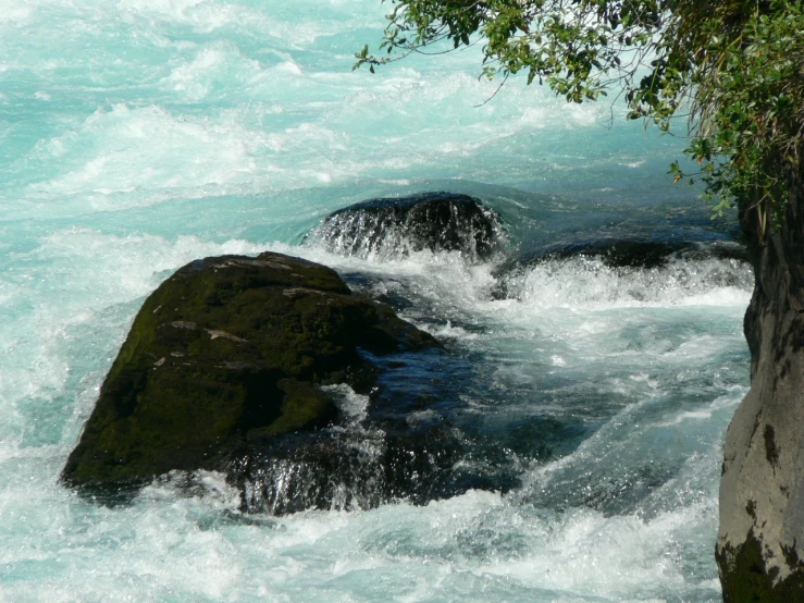 the rapids of a river have small rocks on them