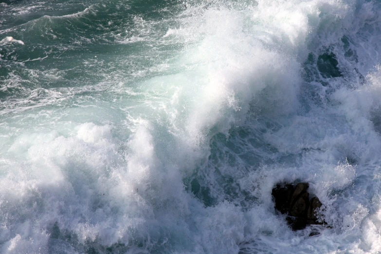 the view from the air of water crashing and crashing into the rocks