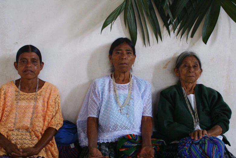 three ladies sitting side by side next to each other