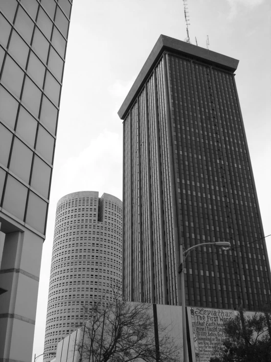 a black and white picture of three buildings with two antennas on top