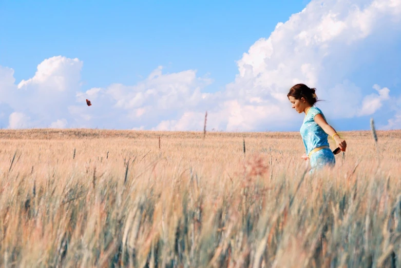 a woman in the middle of a wheat field