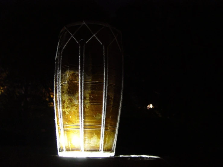 a small well in the middle of a dark field at night