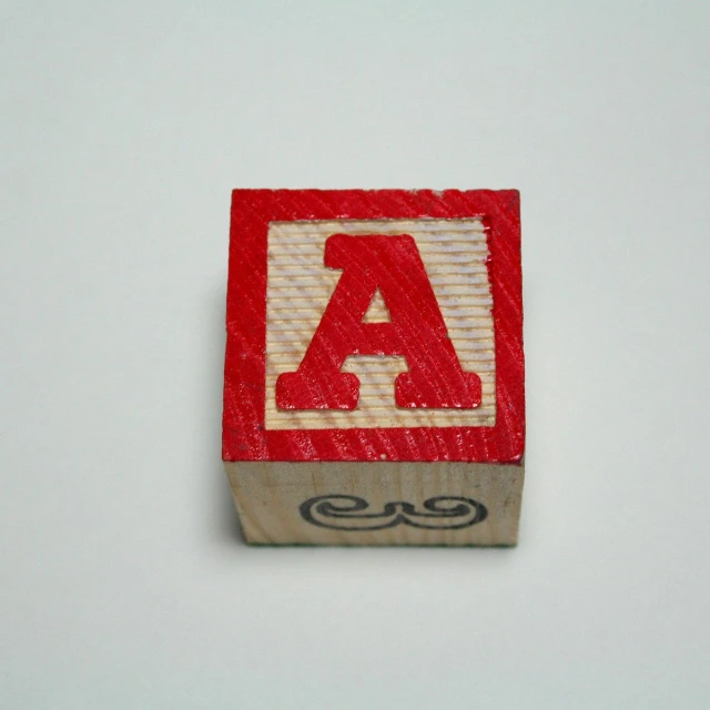 an image of an alphabet block on a white surface