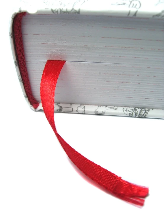 a book is covered with red ribbon