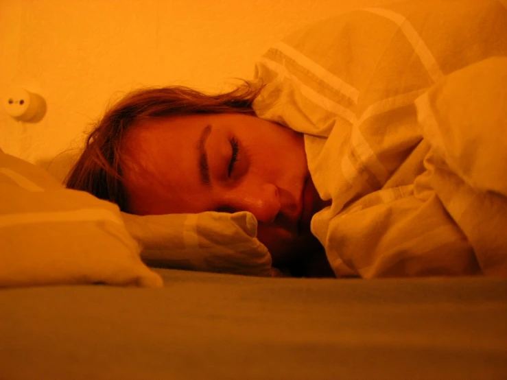 a person is laying in bed with an unmade sheet