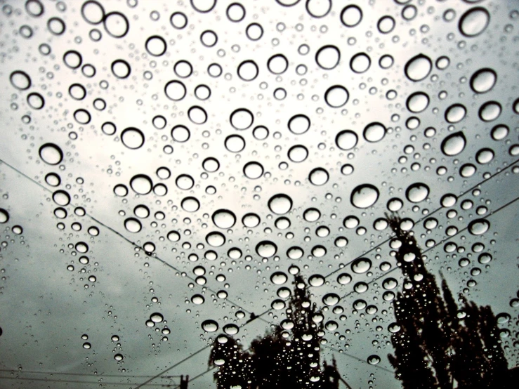 the outside of a rain covered window shows lots of droplets