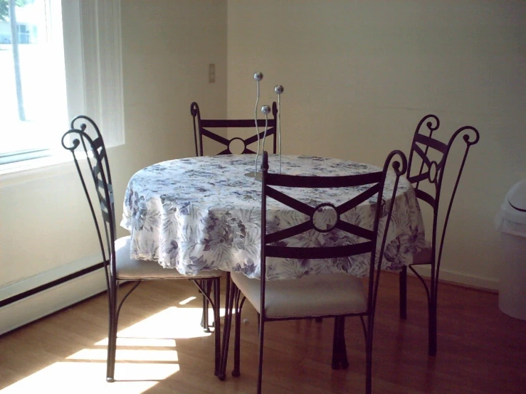 a dining table and chairs are in front of the window