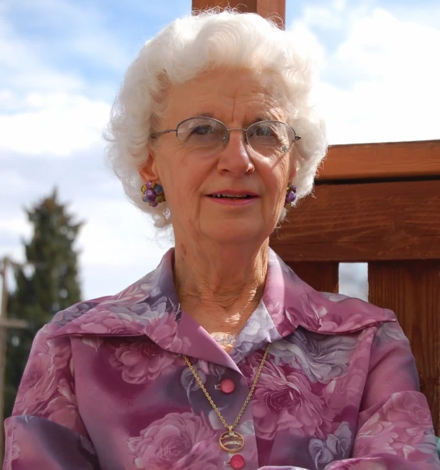 an older woman standing outside smiling for the camera