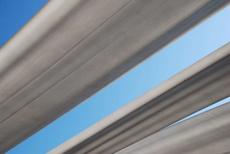 a blue bus is parked underneath two gray structures