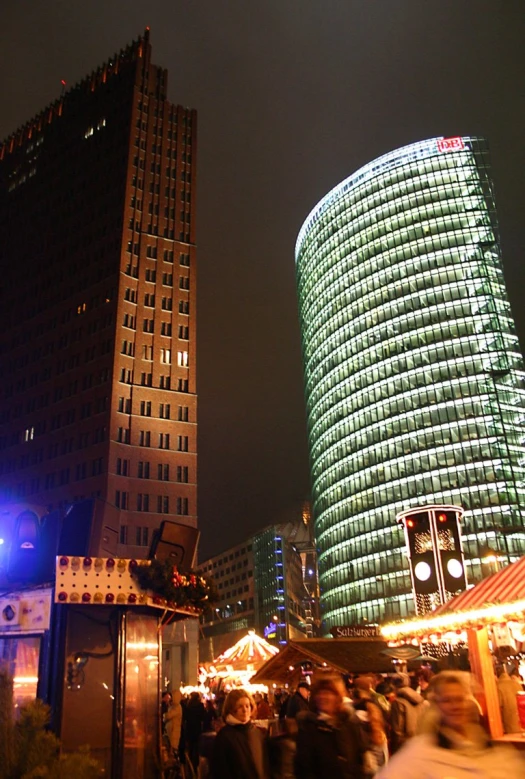 some buildings and people standing around and lights