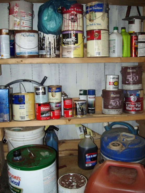 many different types of paint and cans on shelves