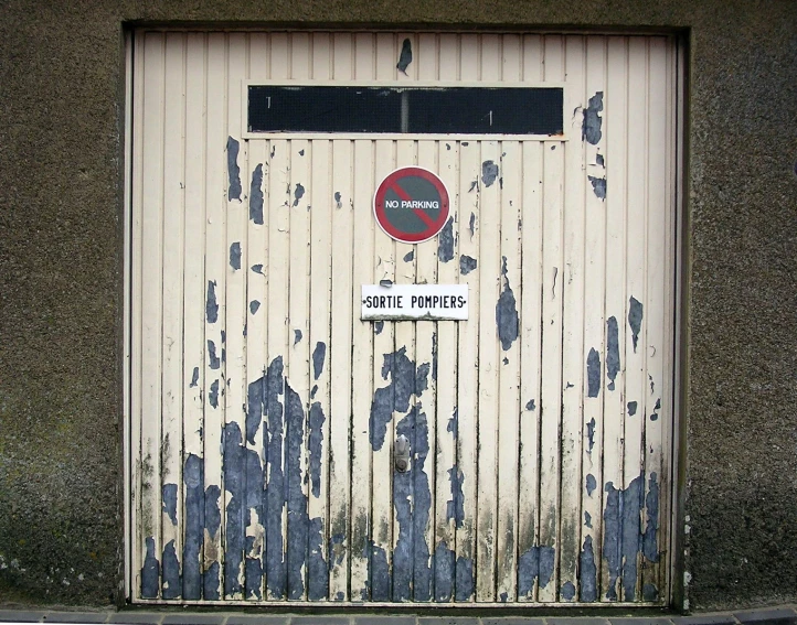 a door on an old garage that is peeling