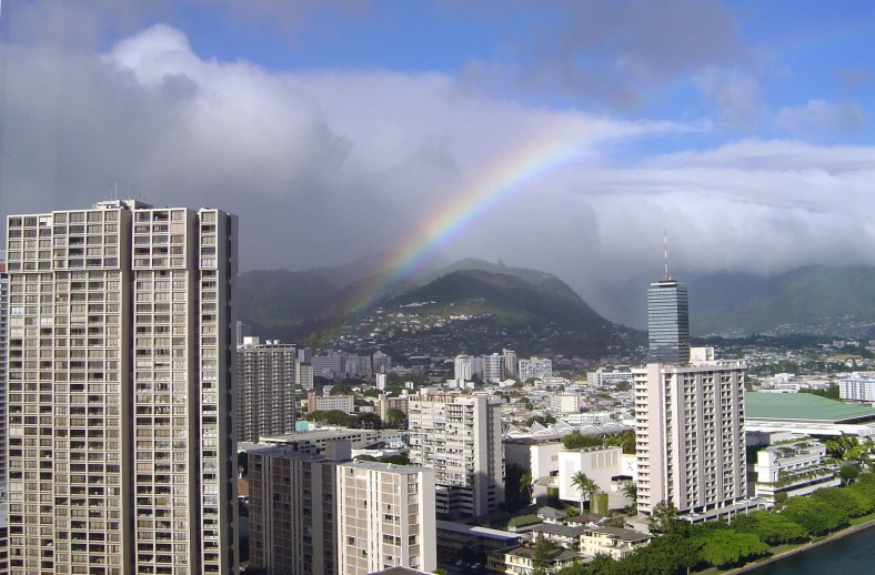 rainbow in the sky over the city with buildings and a harbor