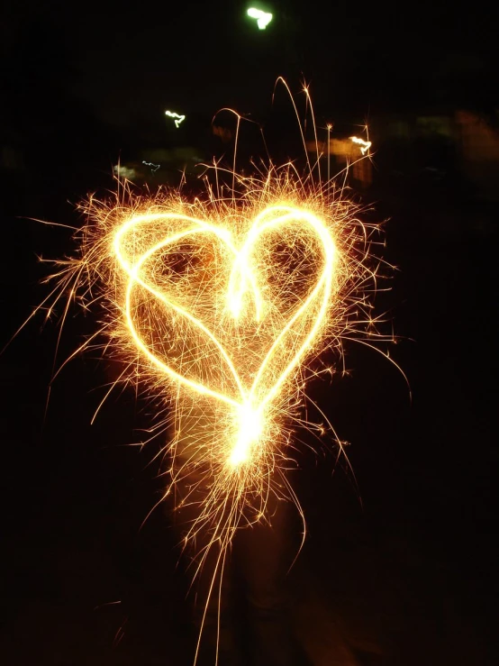 a firework heart and some other sparks in the background