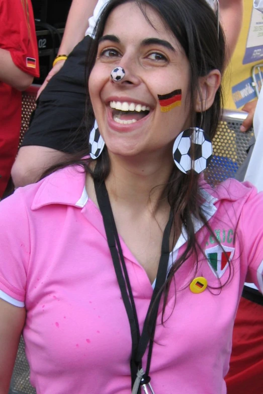 a girl with painted nose, and soccer ear ornaments
