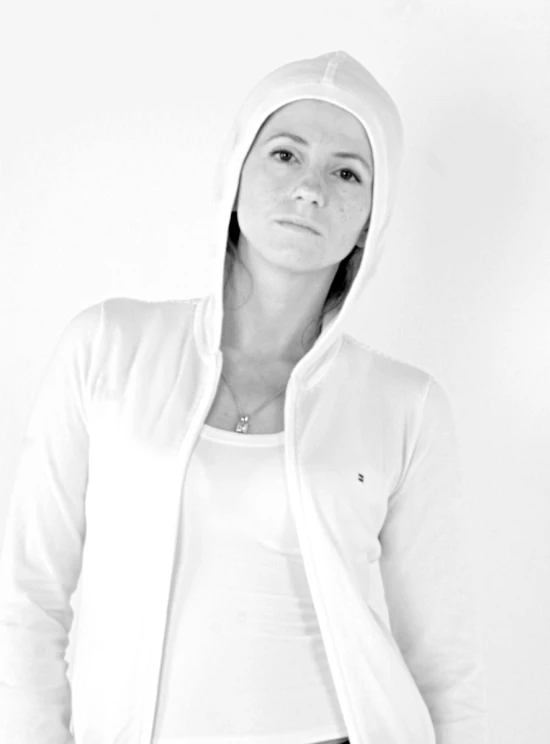 a young woman wearing a hoodie and posing for the camera